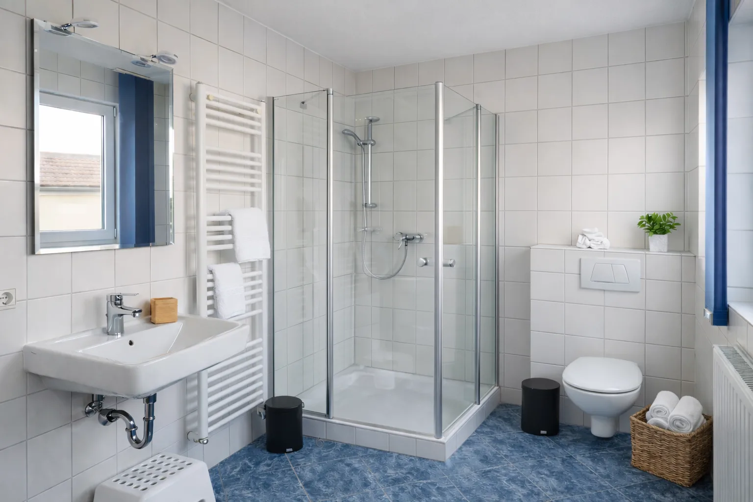 Helles Badezimmer mit Dusche und Handtuchheizung