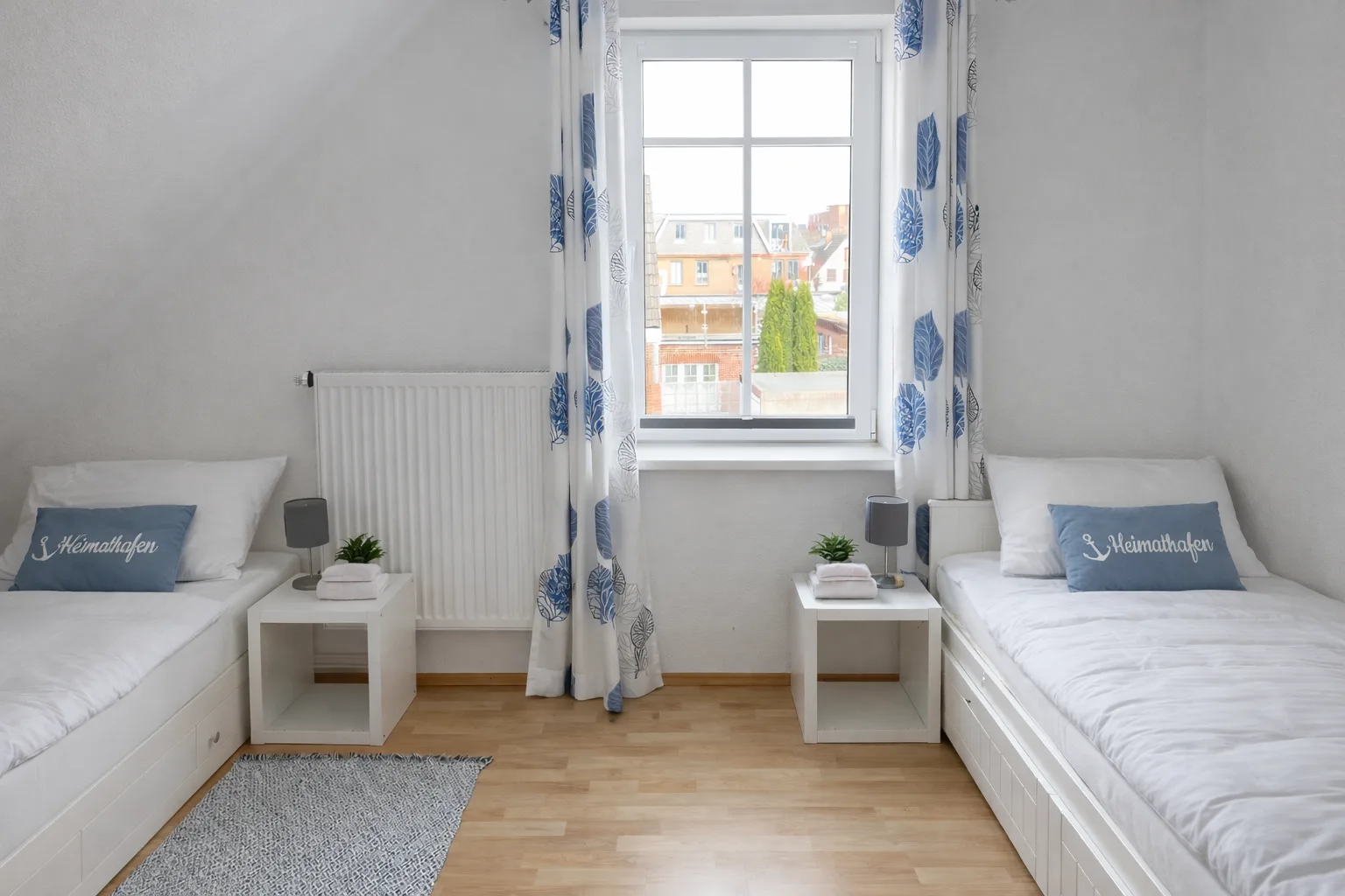 Zweites Schlafzimmer mit zwei Einzelbetten und Heimathafen-Kissen