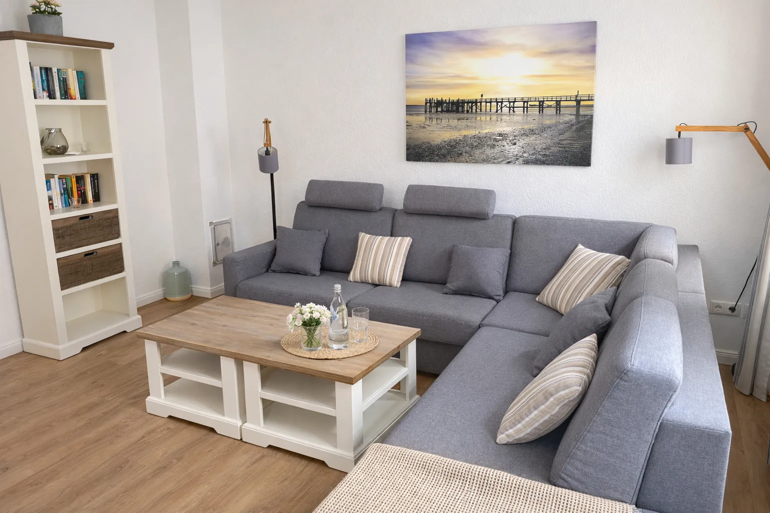 Gemütliches Wohnzimmer des Ferienhauses Seepferdchen auf Föhr mit Sofa und Nordseebild